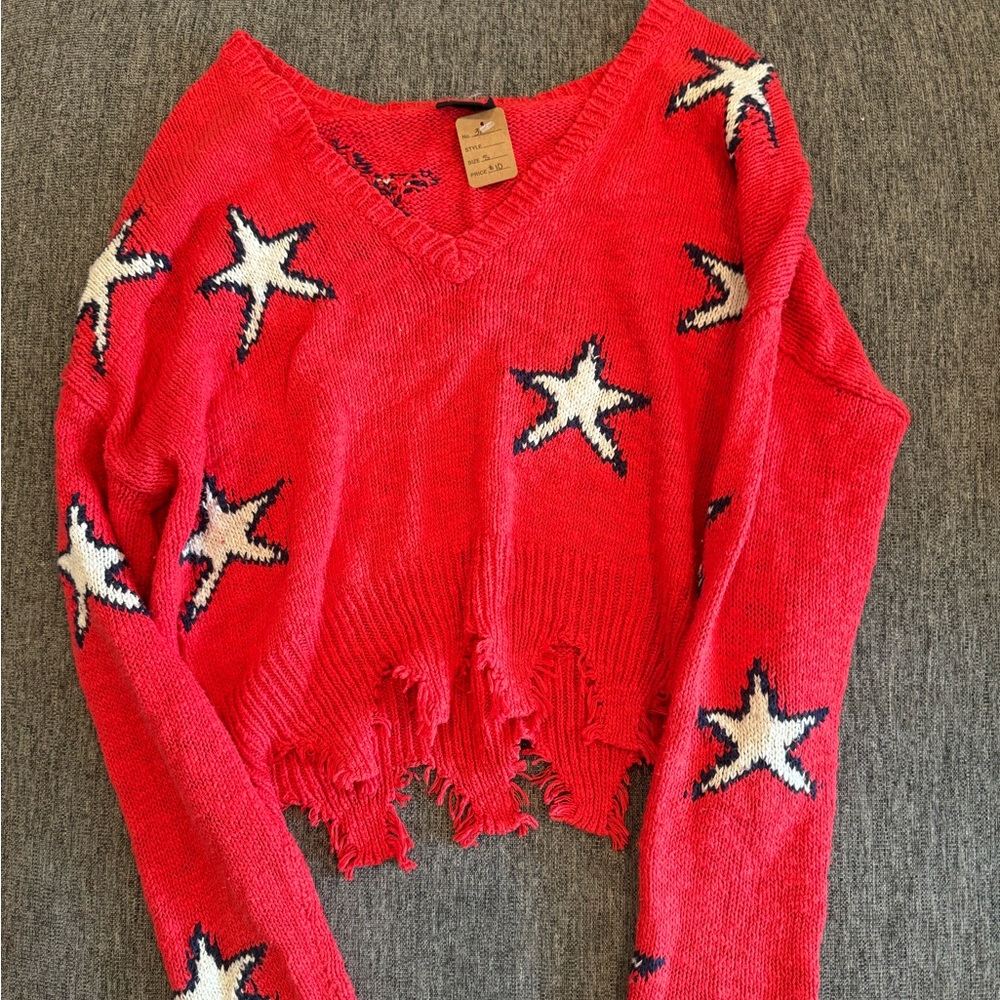 Vici, red, white and blue distressed sweater with star pattern.